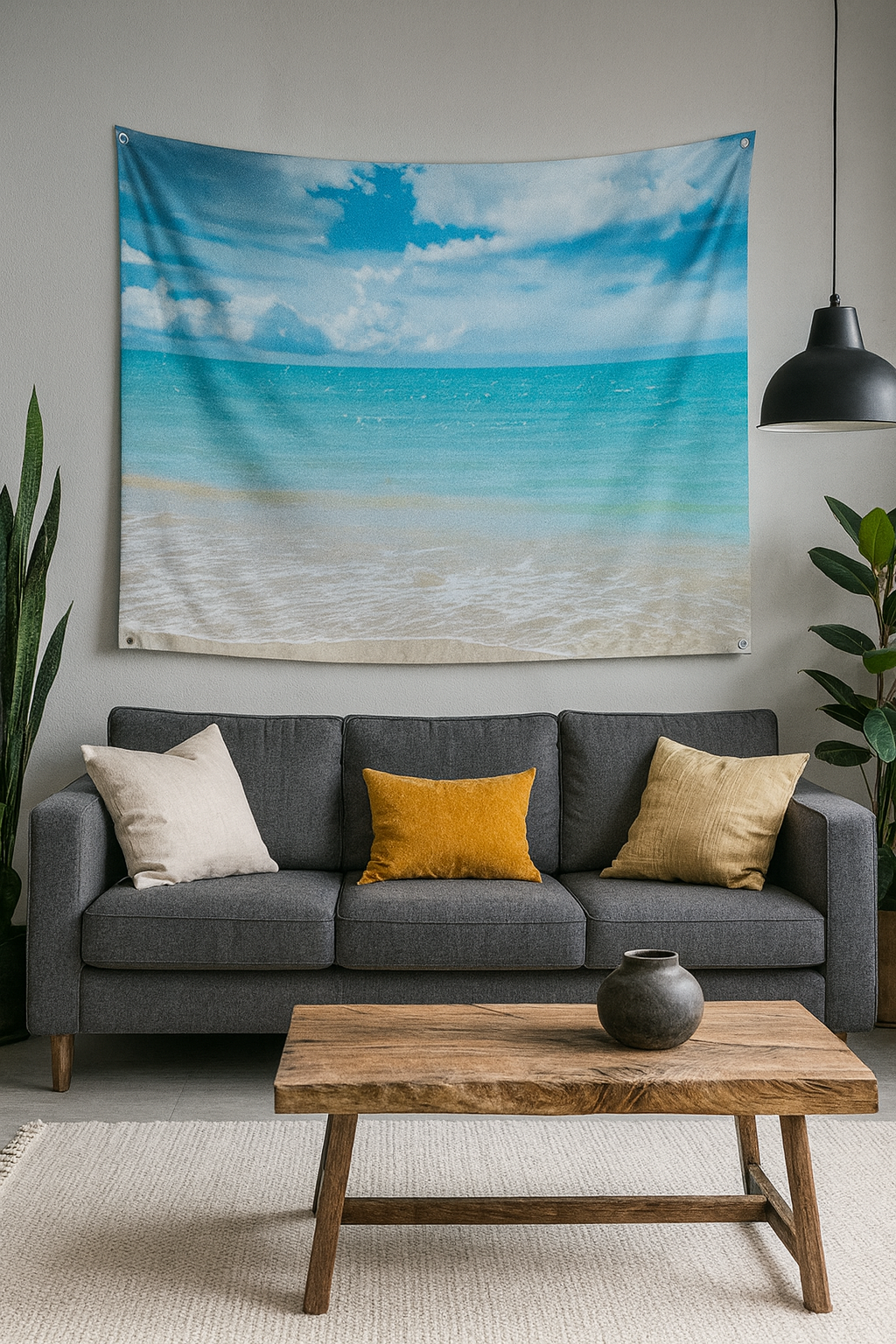 Hawaiian beach tapestry wall hanging with ocean and sky print displayed above a dark grey sofa with yellow accent pillows and wooden coffee table in modern living room